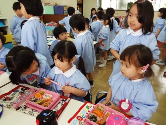 年長さんに給食の用意の仕方を習っています