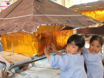 金閣寺に金箔（折り紙）を貼っているところ